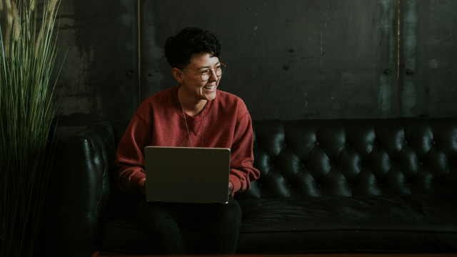 Person sitting on a couch on a laptop